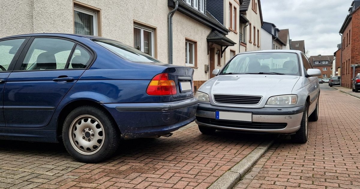 A car blocking a private driveway in front of a garage