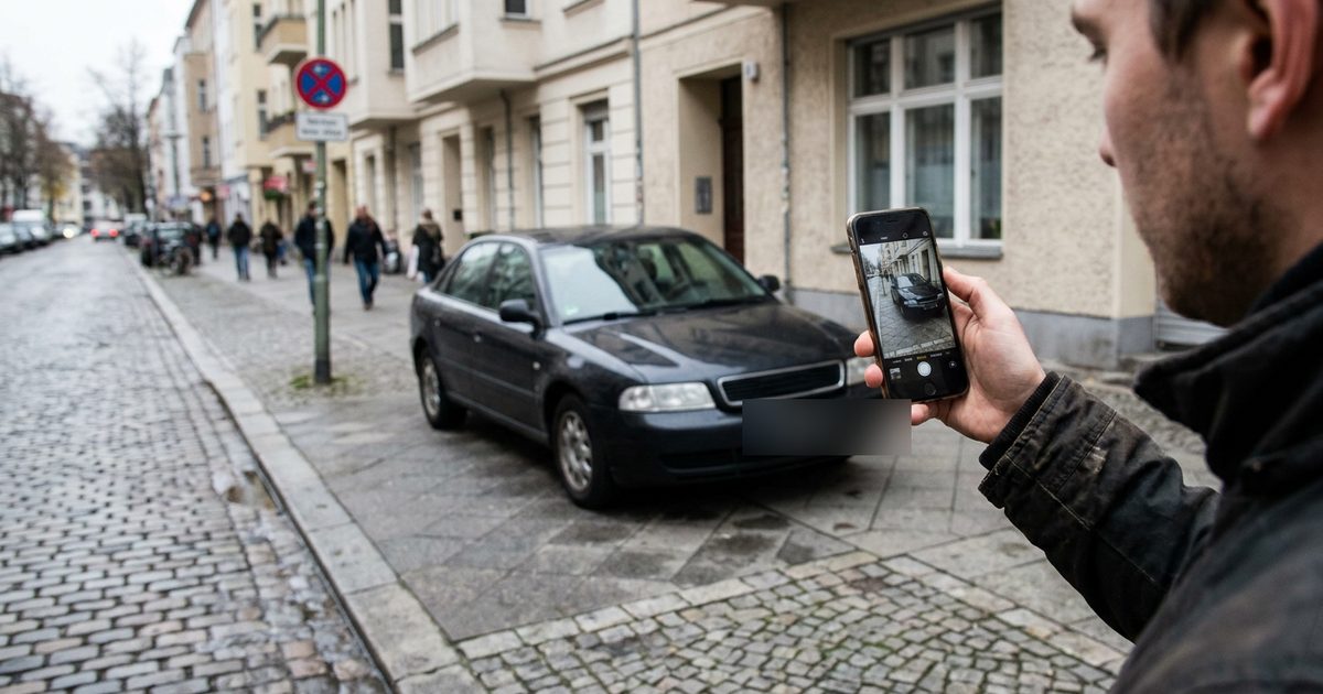 A person photographs an illegally parked car with a smartphone