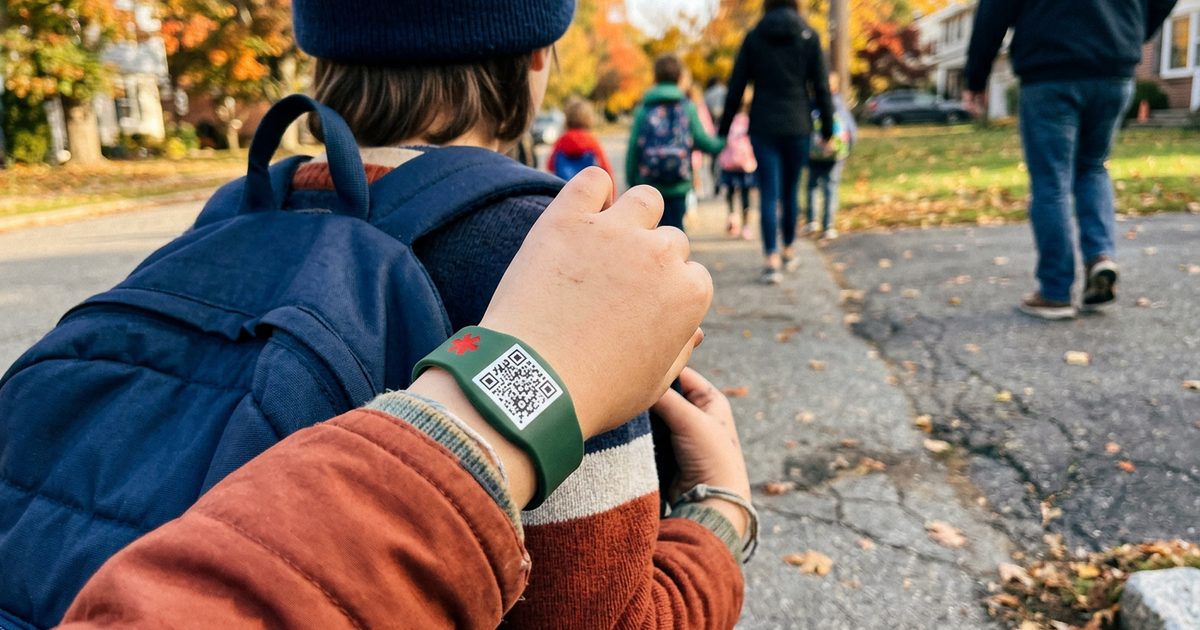 Kind mit Notfallarmband am Handgelenk auf dem Schulweg